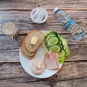 Zdjęcie przedstawia dietę podstawową Jogurt typu islandzkiego naturalny Skyr
Chleb mieszany pszenno-żytni Masło extra Szynka Piastowska Twarożek pomidorowy Ogórek świeży Sałata zielona Kawa zbożowa z mlekiem Woda mineralna